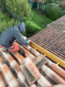 Découpe et ajustement de tuiles lors d’une réparation