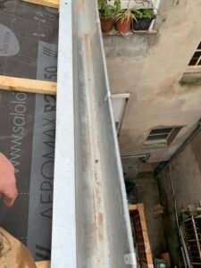 Pose d’une gouttière zinc sur toiture en rénovation