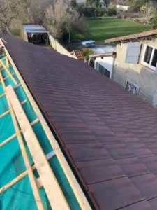 Couverture neuve en tuiles foncées réalisée sur un bâtiment annexe