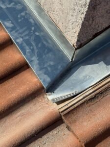 Détail d’une finition zinc étanche au pied d’une cheminée