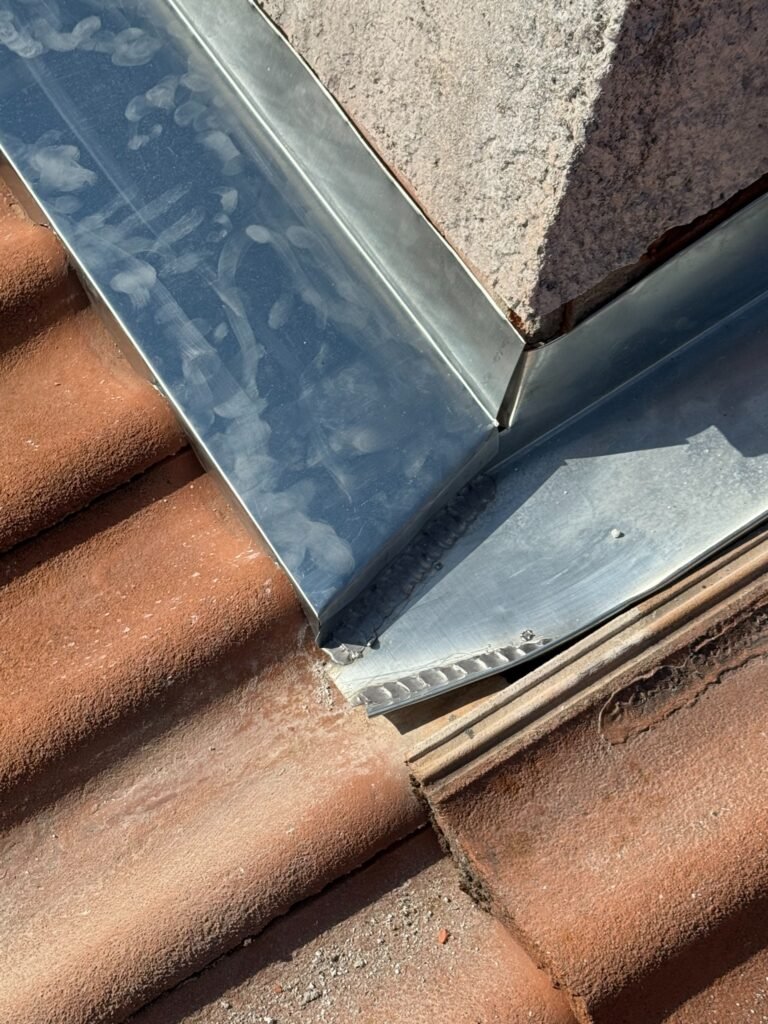 Détail de soudure d’un solin en zinc sur toiture en tuiles
