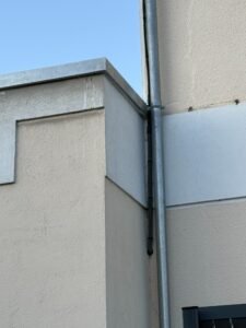 Descente d’eau pluviale en zinc posée sur façade